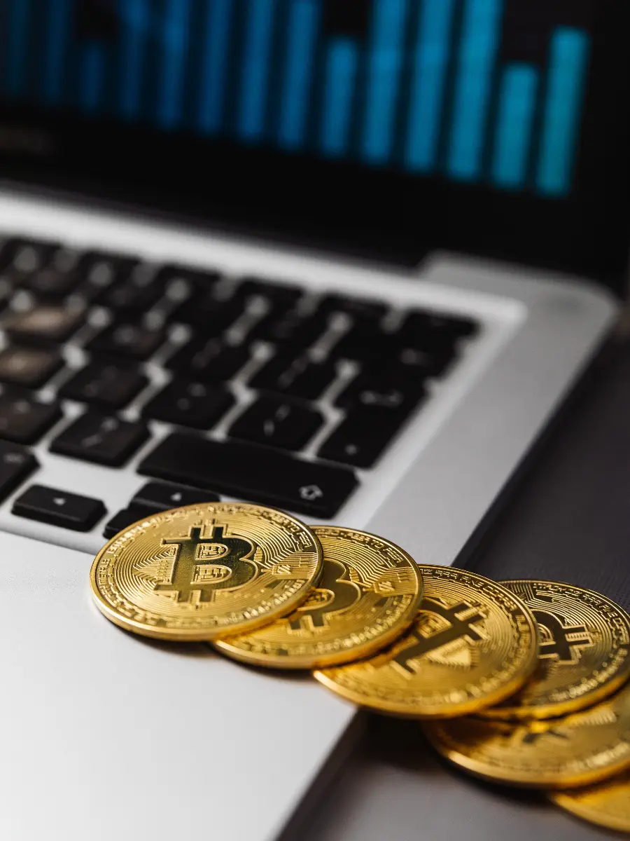 Bitcoin coins on a laptop showing crypto market charts, used to illustrate Australian crypto tax accounting, CGT and DeFi reconciliation for ATO lodgement
