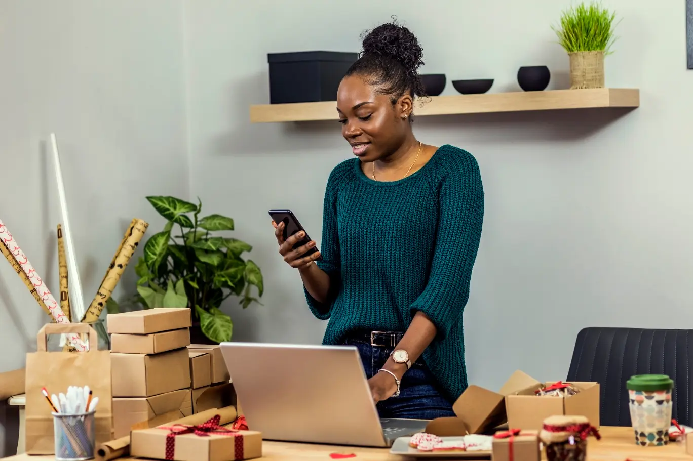Australian eCommerce business owner packing parcels in her home studio while reconciling Shopify, Stripe and Afterpay payouts in Xero for BAS