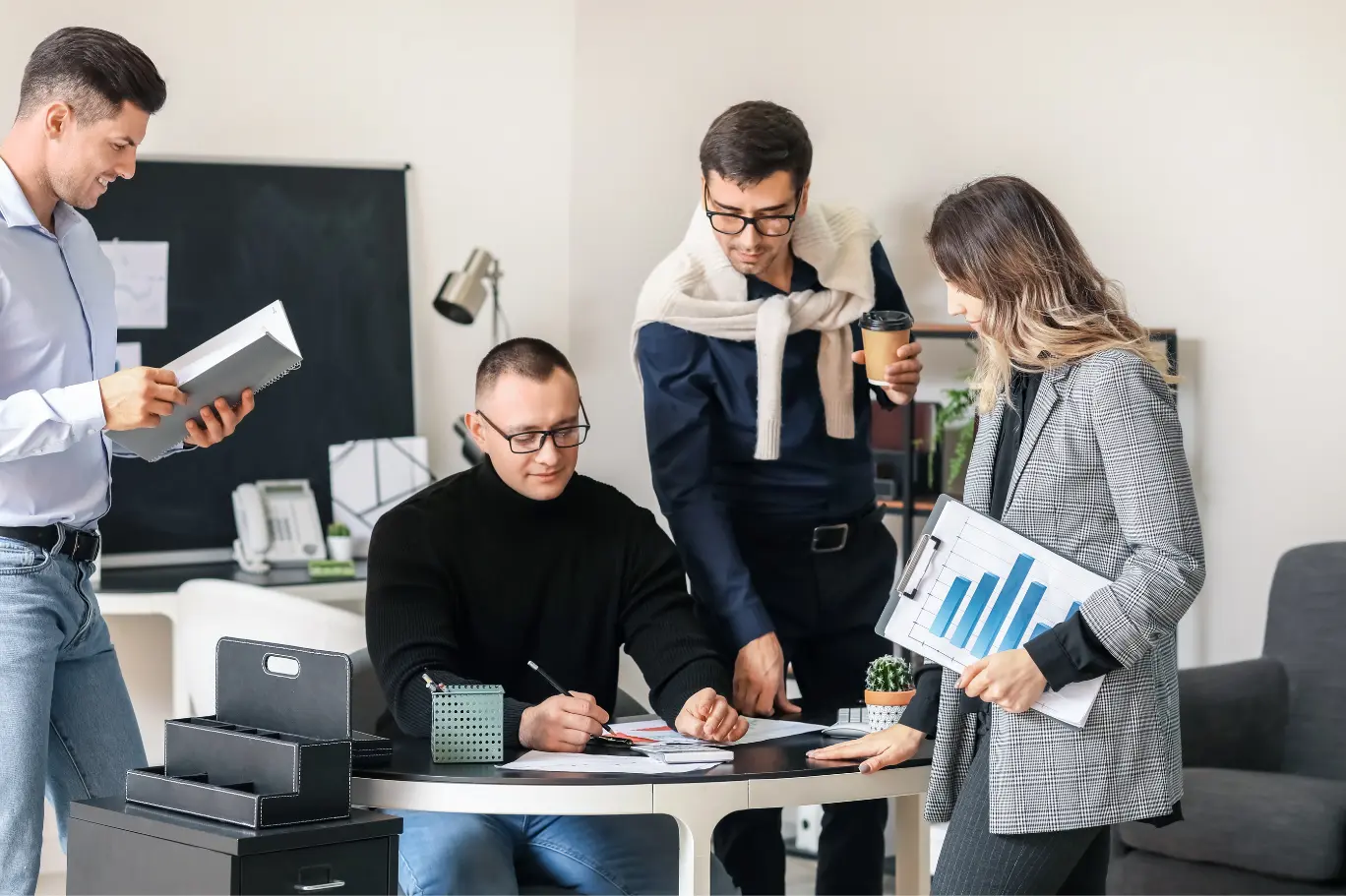 Perth business advisory team huddle reviewing KPI charts, financial reports and a quarterly strategy plan for an Australian SME